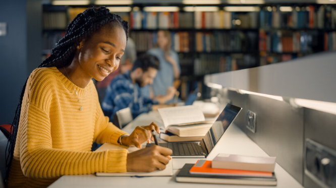 A university student working with course material and a laptop